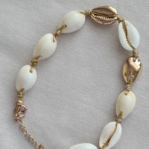 Sommar armband  - Sommar armband med lilla fina snäckor storleken kan man justera med kedjan. 