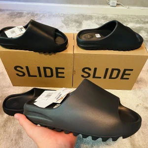 Yeezy slides  - Säljer 2 par yeezy slides onyx i storlek 42 ✅ Båda paren är oandvända och kvitto/äkthetsbevis finns 🧾 Har man några frågor eller vill ha mer bilder är det bara att höra av 😁