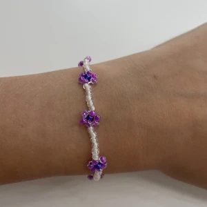 Ett blommigt pärlarmband  - Ett blommigt pärlarmband med lila blommor i storlek s men finns också i fler storlekar om man vill ha kontakta om de uppstår frågetecken!💗💕
