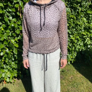 Leopardmönstrad tröja - En långärmad tröja från hm som är leopardmönstrad. Med luva och snören så man kan spänna in den både i midjan och vid luvan. Luftigt och tunt material, lätt genomskinligt