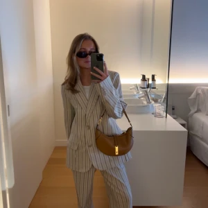Kostym set (kavaj & byxa) - Säljer mitt randiga kostymset, byxor och kavaj från Hanna Schönberg x NA-KD. Den är oversized i modellen. Kan tänka mig att sälja mig plaggen separat men annars tillsammans för givna priset. Knappt använd och i väldigt bra skick.
