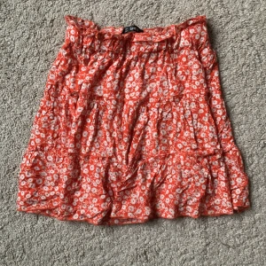 Blommig kjol - Söt orange, kort volangkjol med vita blommor 🌺