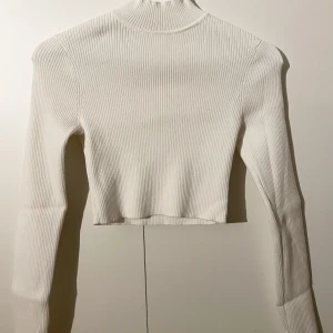 Långärmad croptop  - Ribbad långärmad croptop från H&M i tight modell. Fint skick, använd ett fåtal gånger.