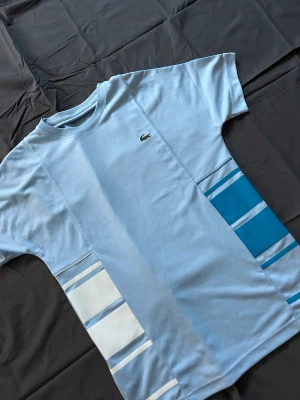 Lacoste T shirt  - En jättefin blå lacoste t shirt. Köpt för 800kr och aldrig använd. Skriv för fler bilder.