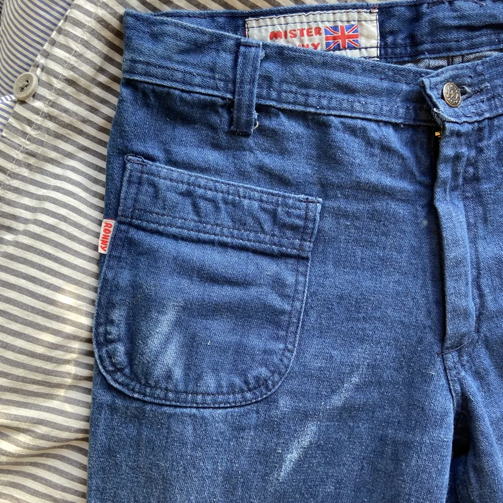 Blå utsvänga jeans med coola detaljer. Finns ingen storlek på byxorna men jag är 1.71 (lite långa på mig) och bär vanligtvis storlek s/m i byxor. Skulle uppskatta dessa som en typisk s. Köpt vintage för 700! Bra skick! Skriv för fler bilder eller frågor💕. Jeans & Byxor.