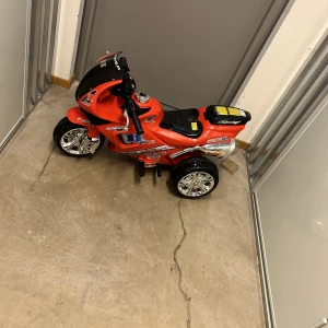 Leksaks motorcykel röd  - En röd låtsas motorcykel som man kan öppna sitt platsen och lägga t:e.x leksaker. Perfekt för små bar 