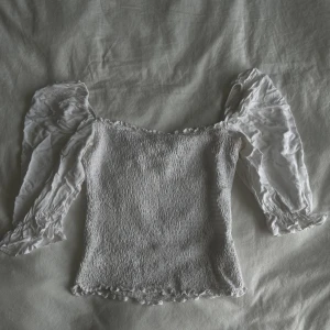 Top med stretch - Vit topp med volang på ärmarna och stretch tyg. 