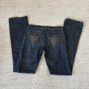 Lågmidjade jeans coola fickor - Jättefina lågmidjade jeans med väldigt snygga mönstrade fickor från sellpy. Innebenlängden är 86 cm och storleken är 28. Pris kan diskuteras. Fråga för fler bilder!💘