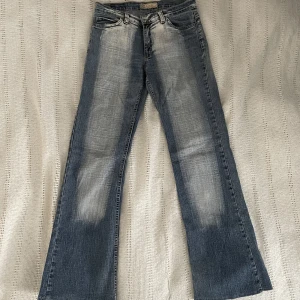lågmidjade jeans - Lågmidjade bootcut jeans, dom är lite slitna men inget som märks tydligt! Jeansen är i lite stretchigt tyg så skulle säga att dom passar S och M. Midja rakt över 36cm, innerbens längd 76cm💓💓