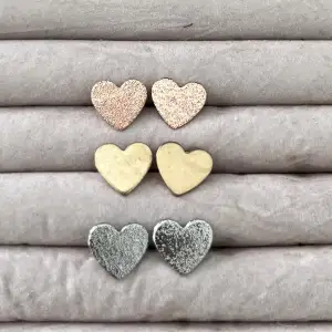 Hjärtörhängen i tre olika färger. Guld, silver och rosa