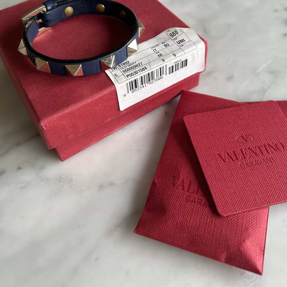 Så fint mörkblått valentino armband med guldiga nitar!! Extra nitar, kort, låda och påse medföljer. Lite sliten men inga större slitage.. Accessoarer.