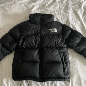 North face jacka  - Supervarm och mysig puffer jacket från the North face i modellen ”retro nuptse 1996”, i fint skick! Den har en luva som man kan veckla ut från kragen! Nypris ca 3600. Storlek S, inga defekter eller liknande, hör av er vid frågor!☺️