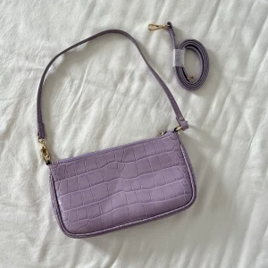 lila läderväska från & other stories  - supergullig lila läderväska med krokodilmönster från & other stories! knappt använt. har två olika band <3 nypris 990kr
