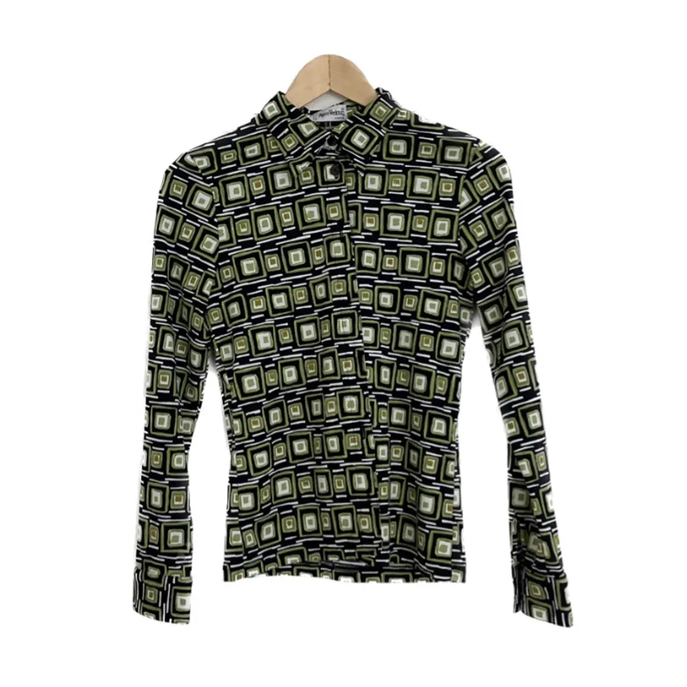 Skitsnygg skjorta med retroinspirerat mönster, gjord i Paris. Finns ingen storlekslapp men uppskattar till en S/M, väldigt smickrande modell som följer kroppen fint.. Skjortor.