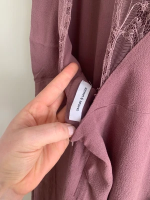 Klänning  - Klänning i en längre modell.  Öppen i ryggen men söt spets.