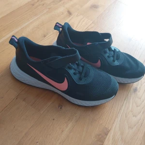 Nike inneskor - Nike revolution inneskor. Är för små så säljer dem. De har ett rosa nike märke på sidan som man kan se på bilden. De är med kardborre och inte knyte så de är lätta att ta på. Tryck inte på "buy now/köp nu" knappen utan skriv privat om intreserad :)