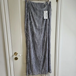 Glittrig kjol - Supernygg glittrig kjol från NAKD. Den är helt ny, endast provad en gång! Lapparna sitter kvar. Jag säljer även den matchande toppen till. Du får hela settet för 300 kr. (Nypris: 229kr + 549kr) Storlek M