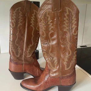 Cowboy boots från Texas  - Äkta cowboy stövlar från Texas USA. Köpta av min mamma på sent 80/tidigt 90-tal. Använda väldigt få gånger och säljs i befintligt skick. Storlek angiven i riktig Texas stil, 5b (b= narrow). Högsta bud och köpare står för frakten.