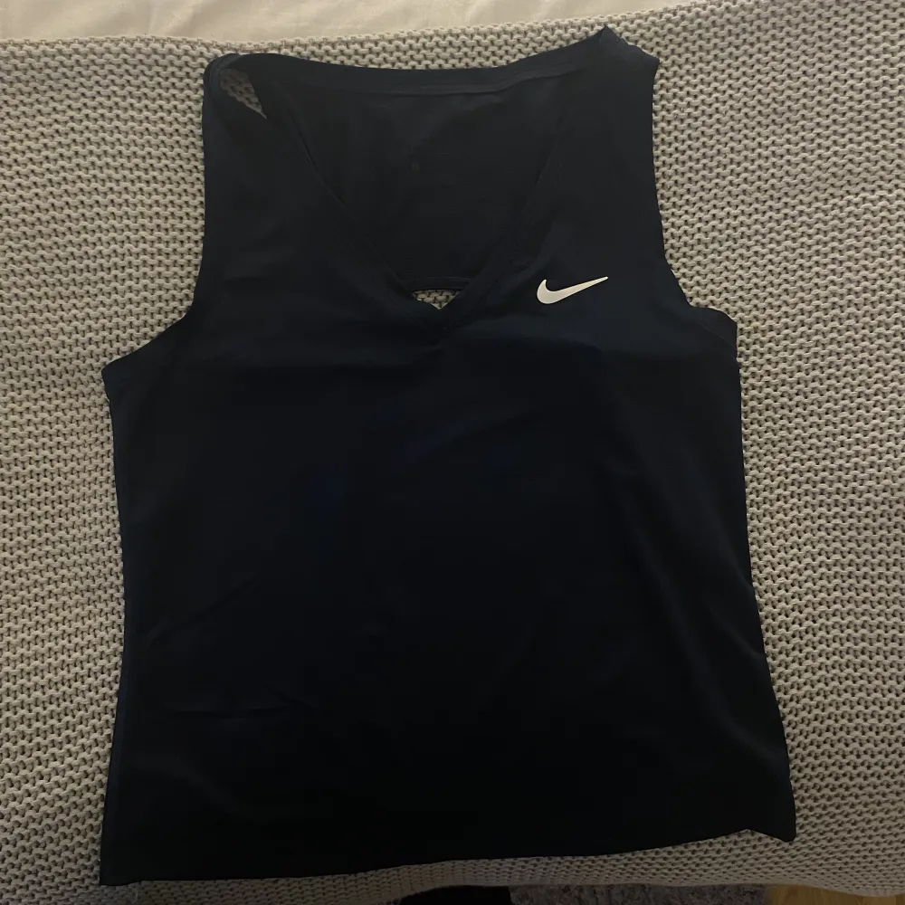 Tennis linne från Nike. V-ringning och luftigt. Färgen är mörkblå och storleken är S. Bra kvalitet.. Toppar.