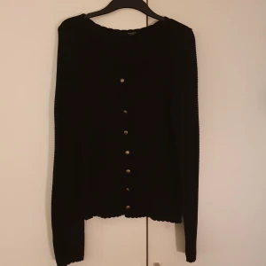 Stickad cardigan M - Stickad svart cardigan med knappar. Använd ett par ggr. Strl M 50%bomull 50%polyacryl  Pris 180kr 