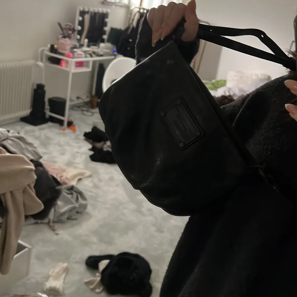En väldigt fin svart Marc Jacobs väska i relativt bra skick men på plattan är den lite repig. Band tillkommer och det finns två fickor på insidan. Väskor.