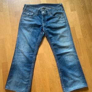 True religon jeans i grym tvätt med ficklock och lätt bootcut .Jag upsize för mer baggy bootcut fit, är strl 29 men dessa är ca strl 31/32. Snyggt lagade baktill som ger rätt vintage feel. 