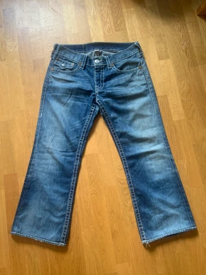 True Religion vintage jeans - True religon jeans i grym tvätt med ficklock och lätt bootcut .Jag upsize för mer baggy bootcut fit, är strl 29 men dessa är ca strl 31/32. Snyggt lagade baktill som ger rätt vintage feel. 