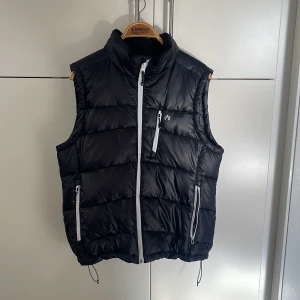 Väst - Väst i varmt och skönt material, i mycket gott skick. Har mysigt material vid hals/nacke. 