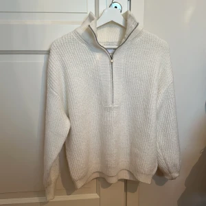 Vit zip-tröja - Skön och mysig stickad tröja från asos. Använd men utan defekter. Detaljer på ärmarna med text ”weekend collective”