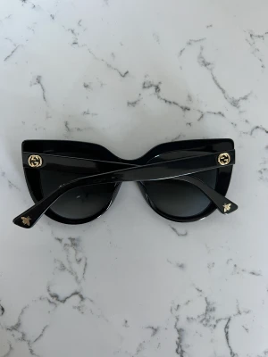 Gucci solglasögon svart - Gucci solglasögon, fint skick.   Modell : GG0164S 001  Storlek : 53  Fodral mm ingår. Även kvitto (köpt online) finns för den som är intresserad.