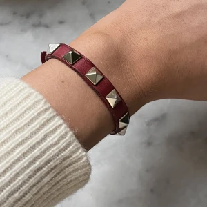 Valentino rockstud leather bracelet  - Ett as coolt rött Valentino armband med nitar på, är ganska slitna på sidorna men inget som syns när det är på😍