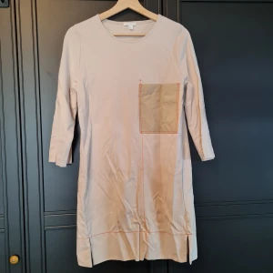 Lång tröja/kort klänning från Cos - Har inte använt på några år så nu är det dags att sälja. Sitter löst, trodde den var i storlek S. Detalj-sömmar är i orange och fickan i annat material. Ärmarna är tre-kvarts.  Bortsett från att den måste strykas så är den princip i ny skick