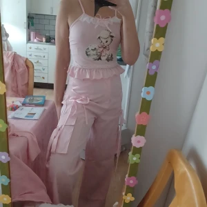Byxa å linne ♡ - Säljer dessa girly cargo byxor och gulligt linne från ROMWE. Byxorna är 40/42, men mindre i storlek. Min midja är xs/small och underdel medium. Dessa sitter som en smäck, lite baggy i midjan men OK. Linnet är small. Säljs separat om ni vill. NYSKICK.