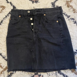 Grå jeanskjol från H&M - Grå jeanskjol från HM i strl 34, i fint skick, köpt för länge sen men knappt använd