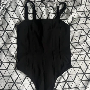 Body - Fin svart korsett body i jättefint skick ifrån H&M. Storlek XS. 