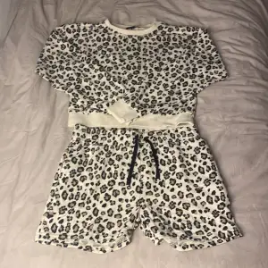 2-set leopard bra på sommaren. Långärmad tröja och shorts med svarta snören