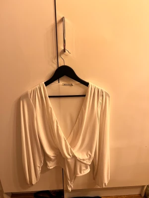 Vit body - Vit långärmad body från Nelly.com, endast använd en gång så väldigt sparsamt använd.