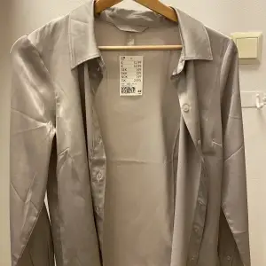 En ny HM grå skjorta silk med prislapp.  Storlek: XS. Originalpriset: 150kr 