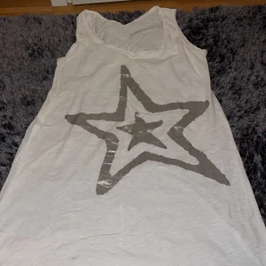 Vit lång tröja  - Vit lång tröja med en silver stjärna har haft på mig den ett par gånger ser ut som ny. 