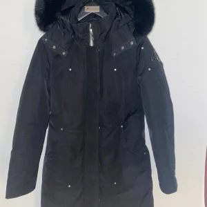 Moose Knuckles Sunwapta  - Säljer denna modell med SVART PÄLS. Nyskick använt 1 månad. Galge och klädsäck medkommer. Stick ut från mängden med all black. Inga byten.