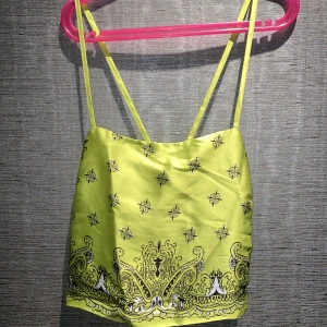 Linne | Bershka - En fin grön topp med mönster på. Den har även en dragkedja på sidan! Den är öppen i ryggen! Från Bershka i storlek Small. Perfekt för ex en neon fest eller till vardags! Skriv privat för mer info och bilder.