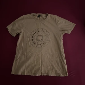 Tshirt - Beige tshirt med astrologi/stjärntecken relaterat tryck på, från Gina Tricot 💕💕 Bra skick, inga defekter eller noppringar!