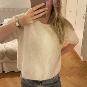 Stickad tröja - Stickad tröja med korta armar, fint skick och sparsamt använd. Bild nr 2 ger mer rättvisa i färgen