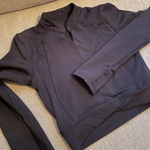 Träningströja  - Märke: okänd.  Strl: står M på etiketten, men känns som en liten xs.  Färg: svarta 