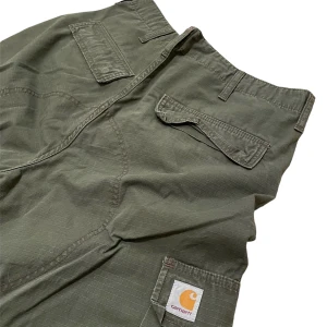 Carhartt byxor - Ett par mörk gröna Carhartt cargo byxor i fint skick. Aldrig använt dem skälv och de saknar defekter. Innerbenslängd: 80cm. Midjemått: 90cm. Benbredd lår: 30cm. Benbredd smalben: 24,5cm. Vid frågor eller önskemål om fler bilder, skriv privat! 