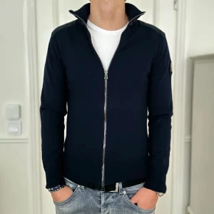 Belstaff Fullzip - En fullzip från Belstaff i storlek M (sitter som S/XS). Tröjan är i nyskick 9/10 utan några som helst defekter. Nypris 2500kr mitt pris 990kr. Modellen är 184 cm och väger 69kg.