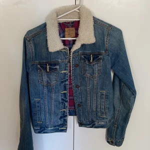 Jeansjacka  - Säljer denna jeansjacka från hollister då den inte passar längre.  Kortare modell, med knappar. Ludder på kragen & precis innanför.  Passar perfekt nu till hösten när det börjar bli kyligare ute.  150 + frakt 😊