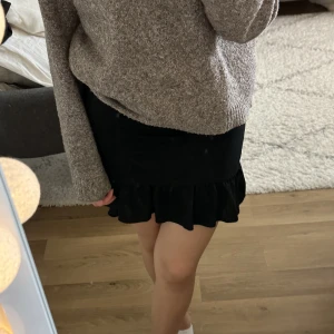 svart kjol - svart kjol med scrunch detalj och volanger, sitter relativt tajt