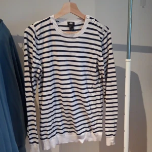 Randigtröja - En basic vit långärmad tröja med mörkblåa ränder och justerbar vid nacken. Jätte fin o jätte skön. Säljer då den inte passar längre💕