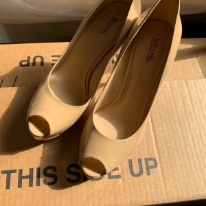 Michael kors högklackat i storlek ”m8” (enligt Google storlek 39-40 möjligen?)  - Ett par Michael kors högklackade skor i beige färg! Små missfärgningar från innan, annars i riktigt bra skick! 